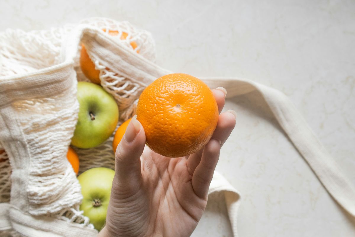 Hand holding orange fruit